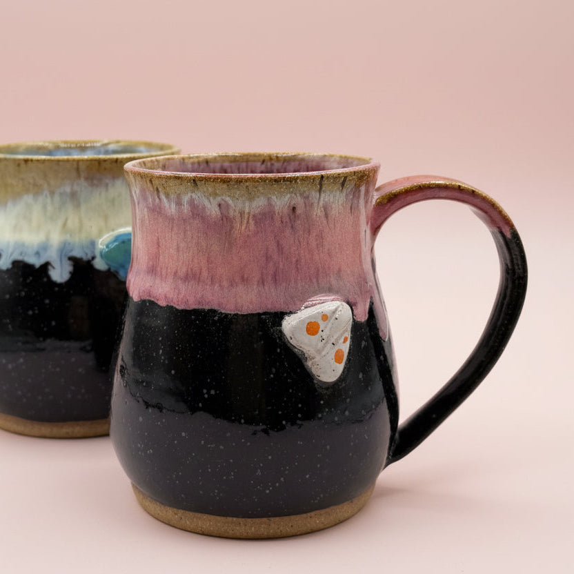 Two ceramic mugs with gradient glaze on a beige background