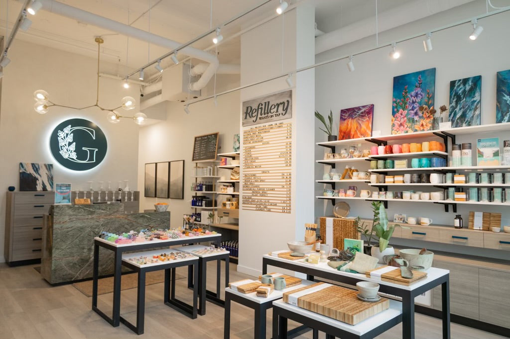 Greenbriar Market interior with illuminated G logo, refill bar, handmade ceramics, sustainable home goods, local art, and vibrant displays of Canadian-made products.