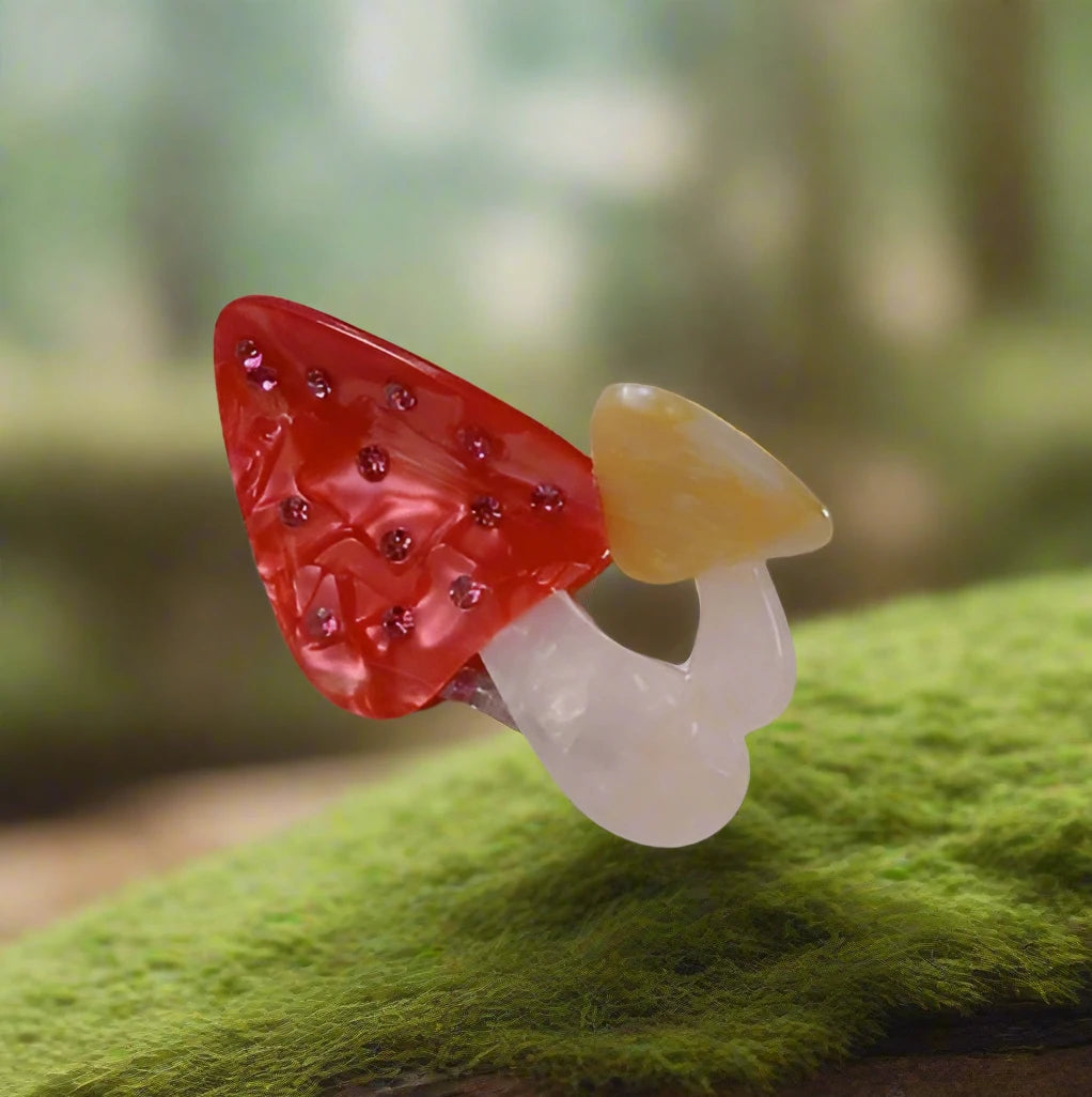 Whimsical red mushroom hair clip styled on forest moss, Calgary accessories for nature-inspired fashion.