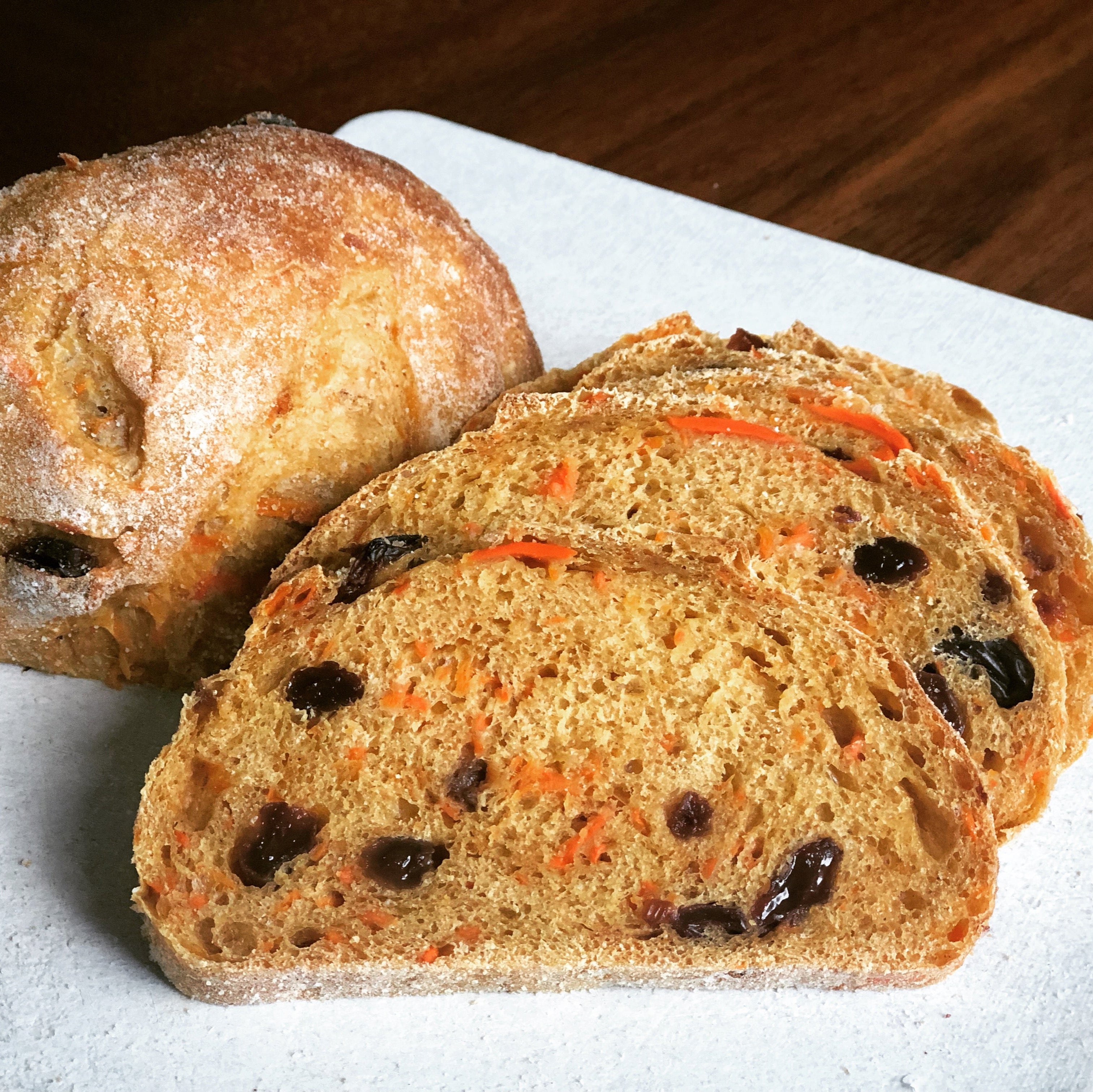 Sliced carrot cake sourdough bread with raisins on a white board in Calgary