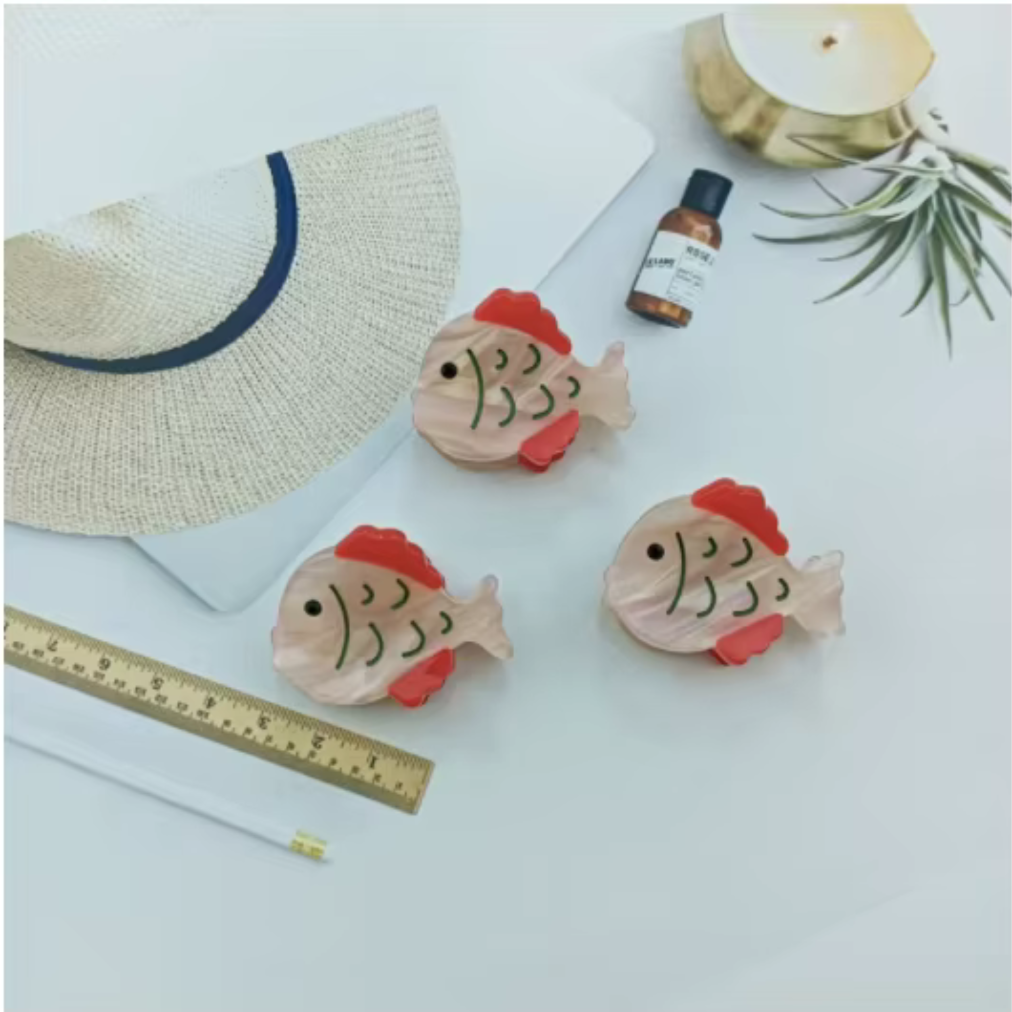 Set of pink and red fantail fish-shaped mini hair clips made from cellulose acetate – photographed in Calgary on a white background.