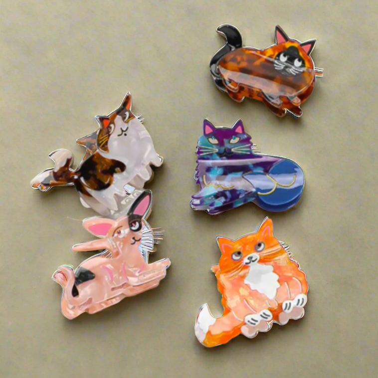 Illustrated cat-shaped hair clips on amber background – Calgary cellulose acetate hair accessories by Greenbriar Market