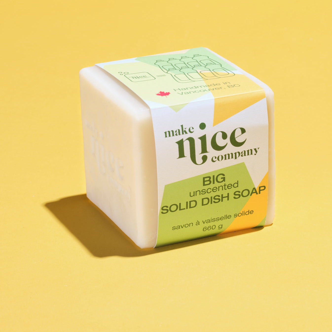 Large Make Nice Company Unscented Solid Dish Soap in compostable packaging, sitting on a yellow background. A sustainable alternative to liquid dish soap.