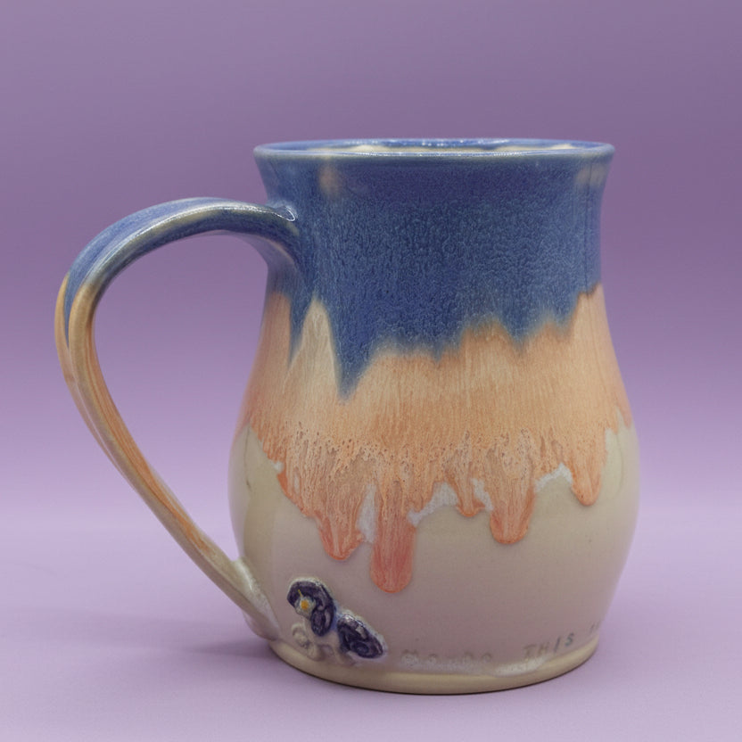 Ceramic mug with blue and orange glaze on a white background
