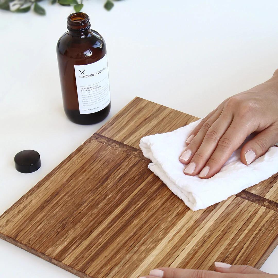 Applying butcher block oil to wooden cutting board with cloth – Calgary kitchen care