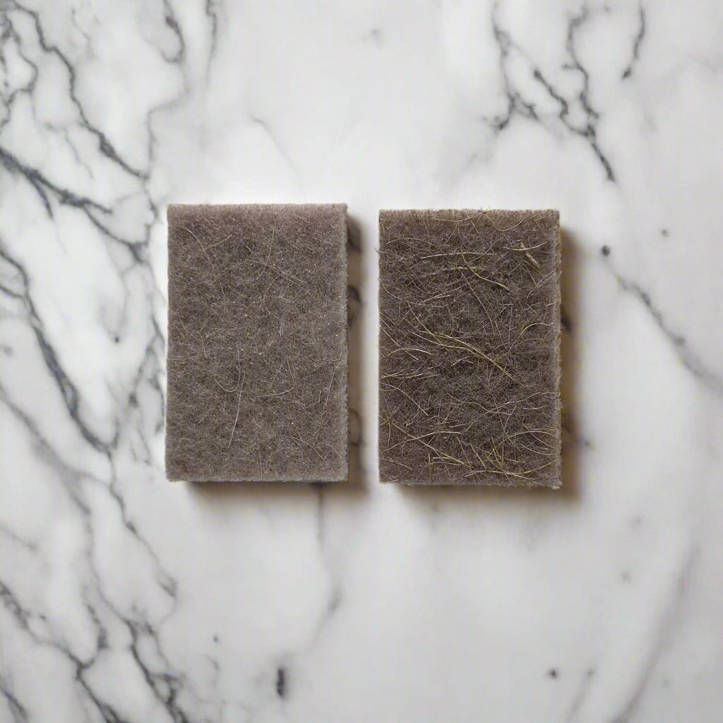 Natural fibre scouring pads on white marble kitchen counter – compostable cleaning pads in Calgary from Cuprea