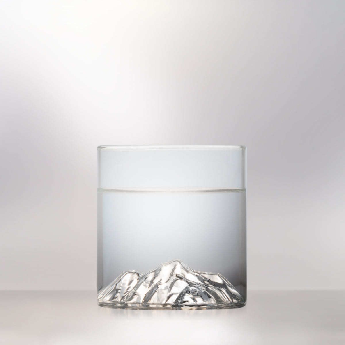 Glass tumbler with 3D relief of Pyramid Mountain photographed on a white background for product display
