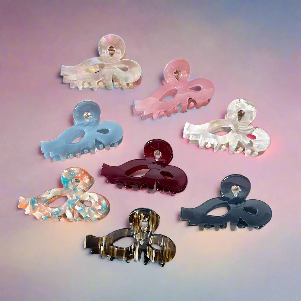 Sculptural claw clips from Sebeana in soft marbled colours on a pink gradient – Calgary sustainable hair accessories