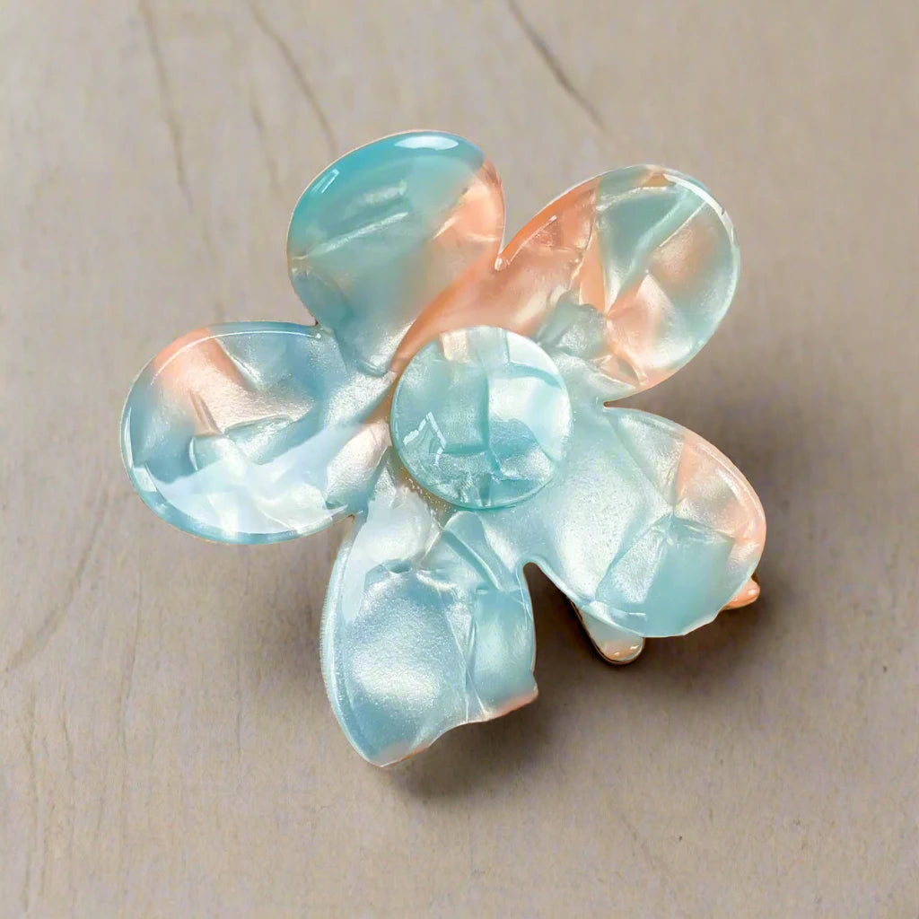 Sky blue and apricot daisy hair clip on light wood – best Calgary hair accessories from Sebeana